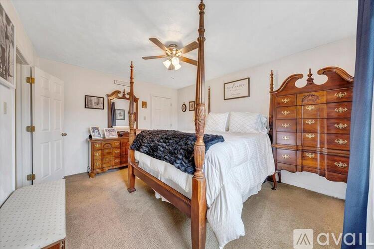A bedroom with a four poster bed and a dresser.