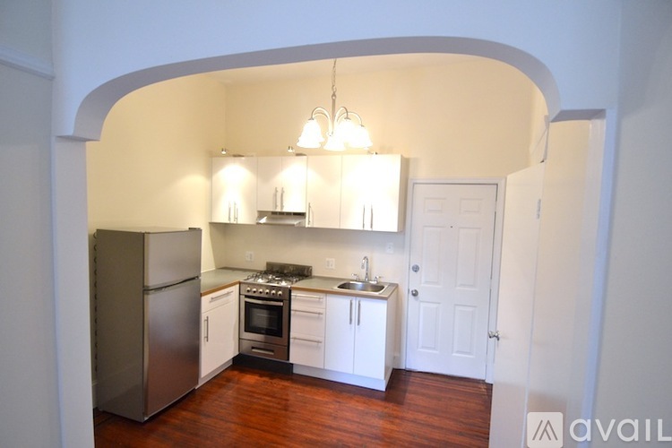 A kitchen with a refrigerator, stove, and sink.