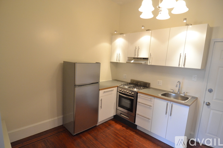 A kitchen with white cabinets and a stainless steel refrigerator.
