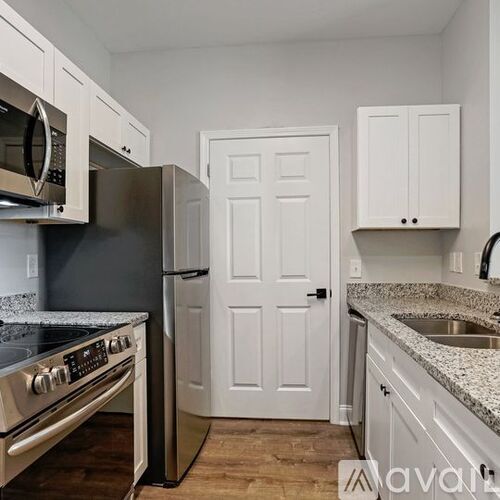 A kitchen with white cabinets and a stainless steel refrigerator.