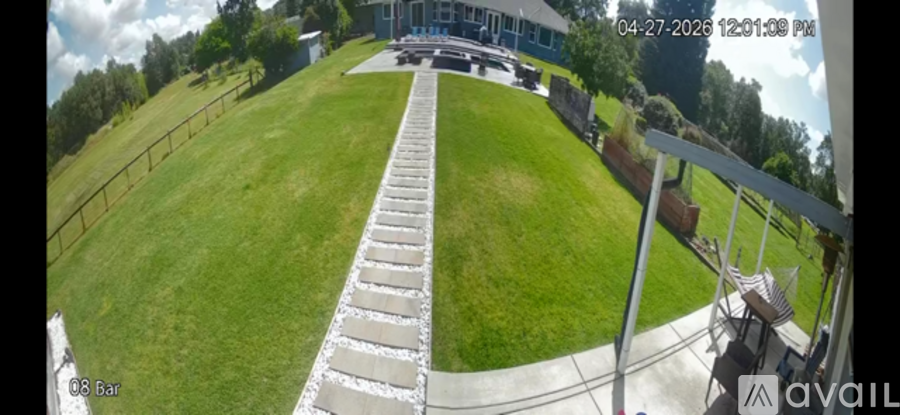 A grassy hill with a concrete pathway leading up to a house.