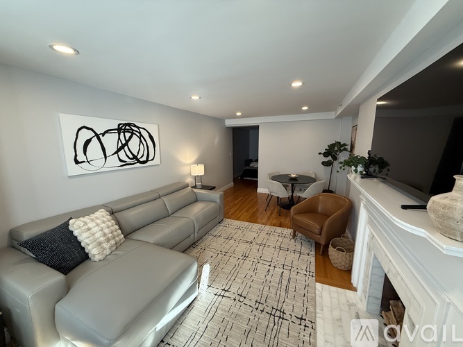 A living room with a grey couch and a painting on the wall.