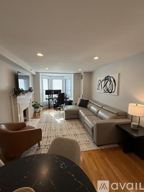 A living room with a fireplace and a large painting on the wall.