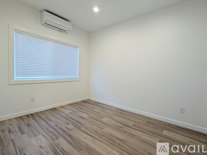 A room with a window and wooden flooring.