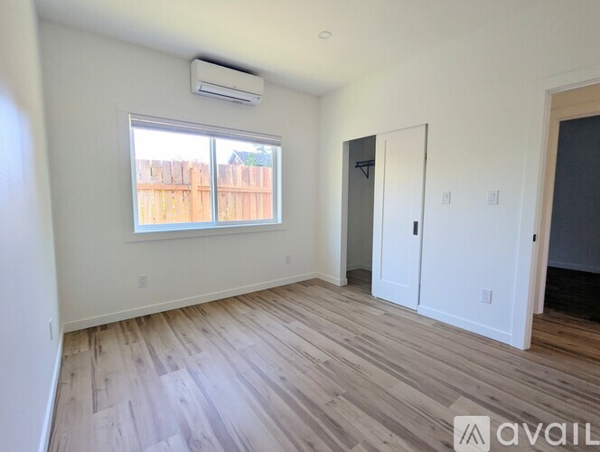 A room with a window and wooden flooring is available for rent.