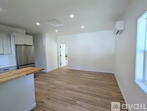 A kitchen with white cabinets and a wooden countertop.