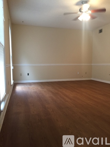 A room with wooden floors and a ceiling fan.