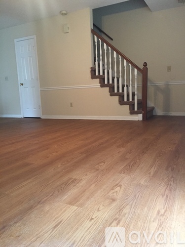 A room with wooden flooring and a staircase.