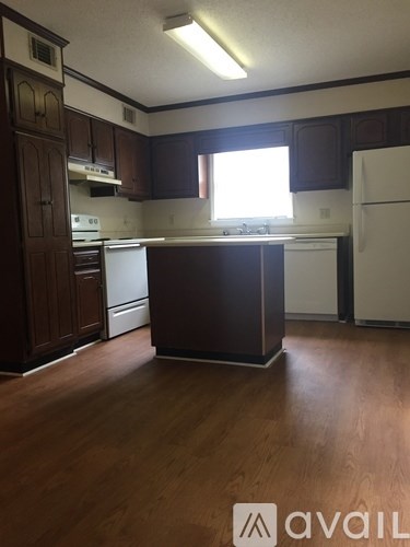 A kitchen with brown cabinets and a white fridge.