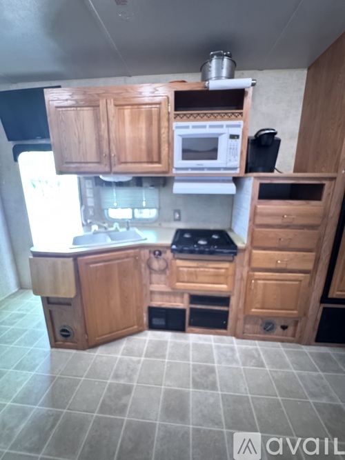 A kitchen with wooden cabinets and a tiled floor.