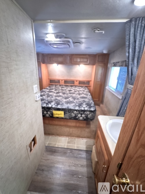 A small bedroom with a bed, sink, and window.