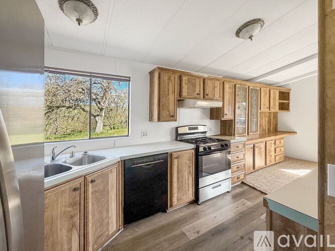 A kitchen with wooden cabinets and a white stove top oven.