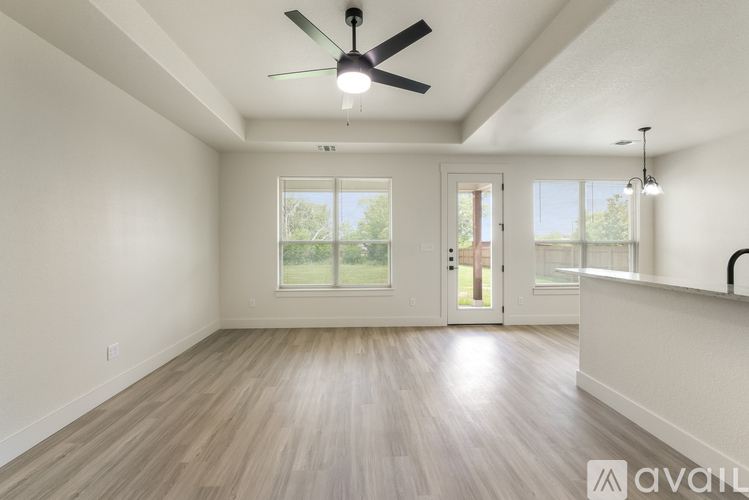 A spacious room with a ceiling fan and sliding glass doors.