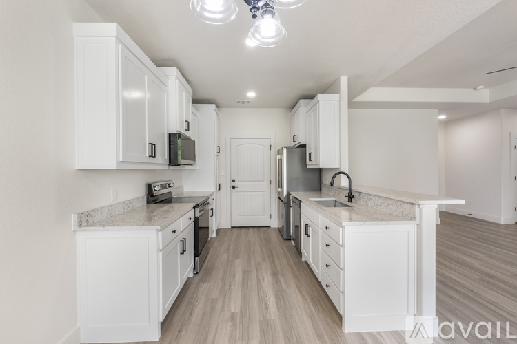 A kitchen with white cabinets and a wooden floor.