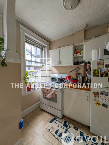 A kitchen with a refrigerator, oven, and cabinets.