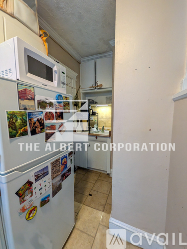 A kitchen with a fridge covered in photos and magnets.