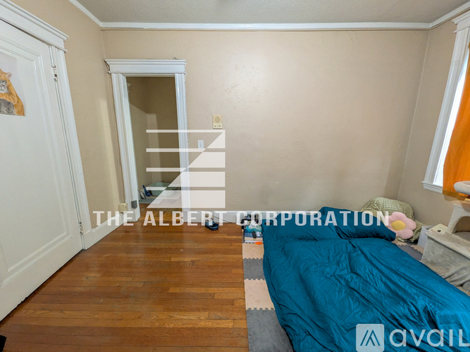 A bedroom with a bed, dresser, and window.
