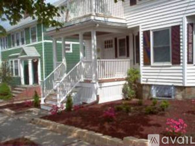 A white house with a green front porch.
