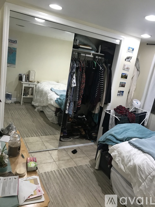 A bedroom with a bed, a wardrobe, and a mirror.