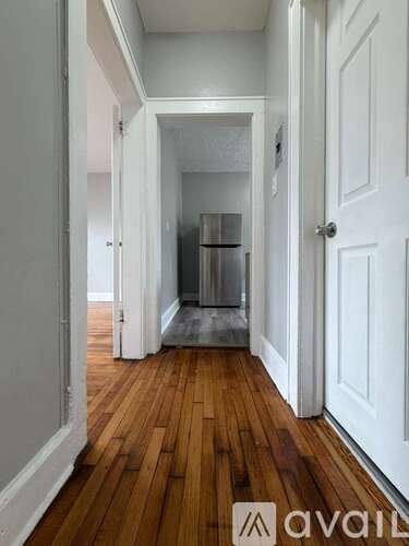 A hallway with wood floors and white walls.