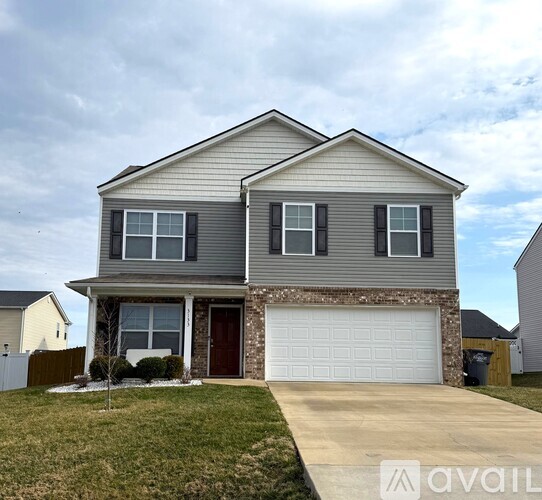 A two-story house with a garage and a driveway.