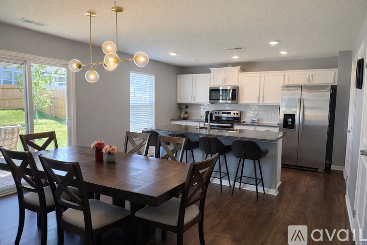 A kitchen with a table and chairs in front of it.