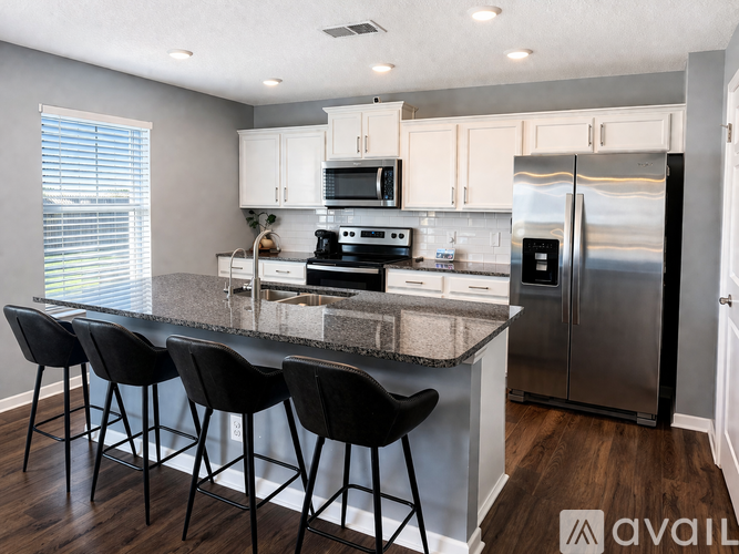A kitchen with a granite countertop and stainless steel appliances.