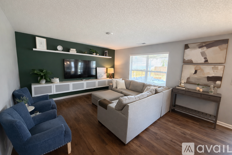 A living room with a blue chair and a grey sofa.