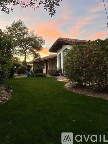 A house with a lawn and trees in front of it.