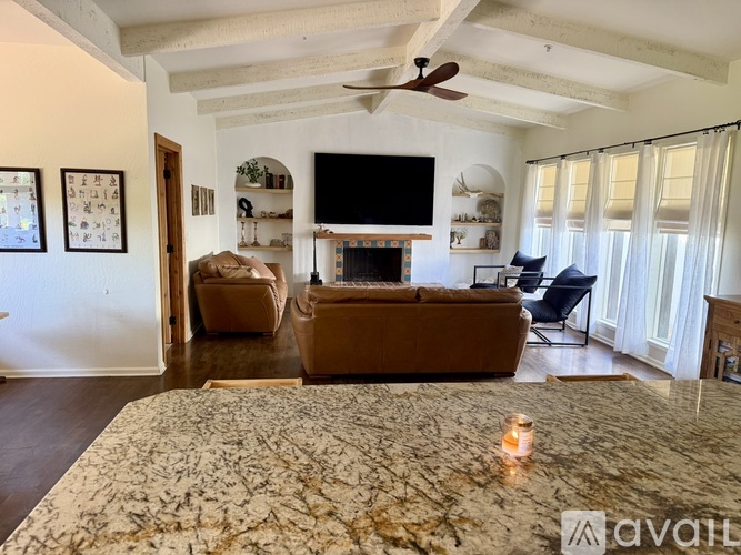 A living room with a fireplace and a television on the wall.