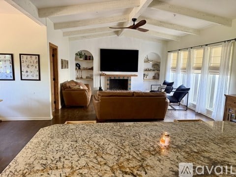 A living room with a fireplace and a television on the wall.