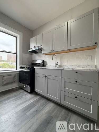 A kitchen with white cabinets and a black oven.