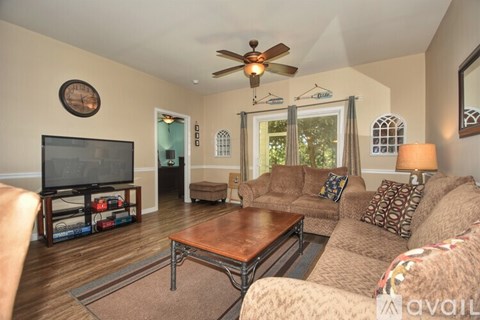 A living room with a brown couch and a wooden coffee table.