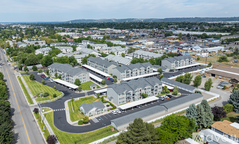 A large building complex with a parking lot in front.