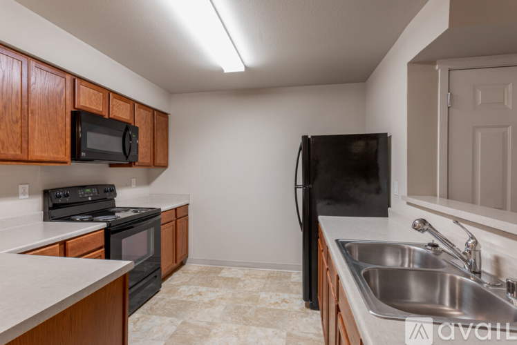 A kitchen with a black fridge and a black microwave.