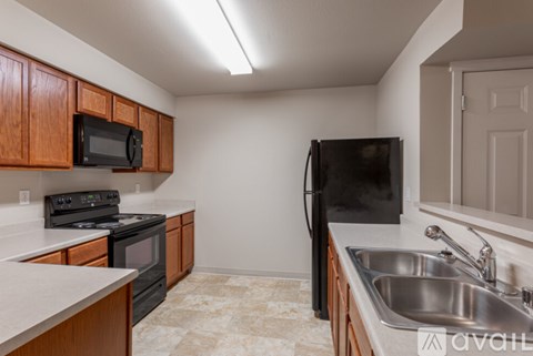 A kitchen with a black fridge and a black microwave.