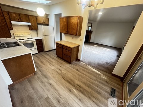 A kitchen with wooden cabinets and a white refrigerator.