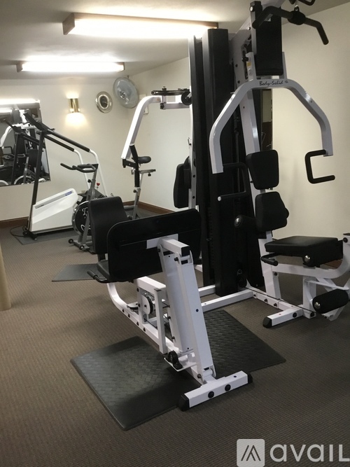 A gym with a variety of equipment including a leg press machine.