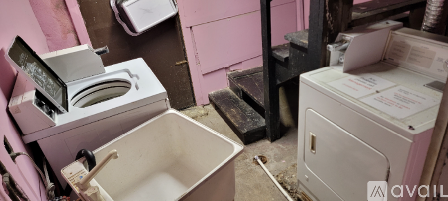 A dirty bathroom with a toilet, sink and washing machine.