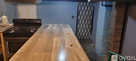 A kitchen with a wooden counter top and a black stove.