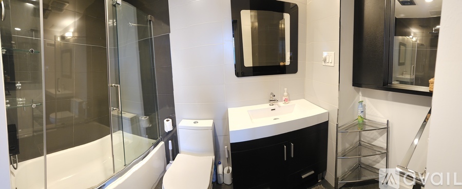 A bathroom with a white sink and a black mirror.