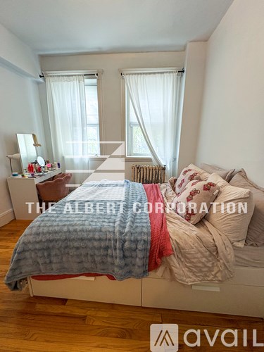 A bedroom with a bed covered in a blue and red blanket.