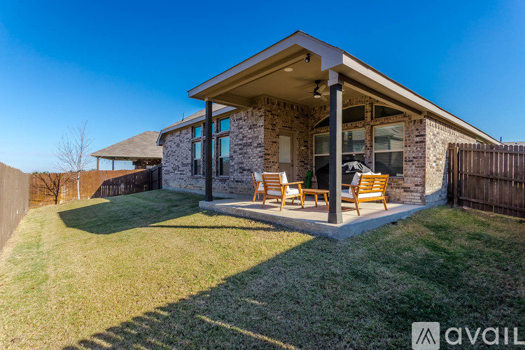 A house with a patio and chairs is available for sale.