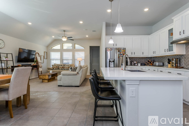 A modern kitchen with white cabinets and a large island.