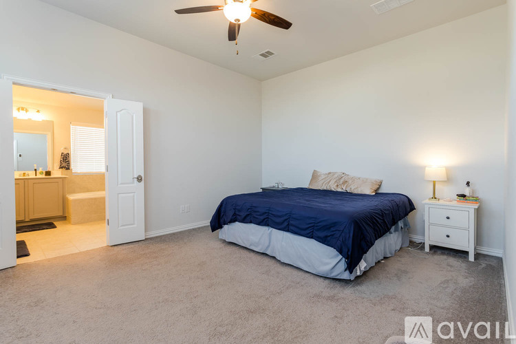 A bedroom with a bed, nightstand, and a ceiling fan.