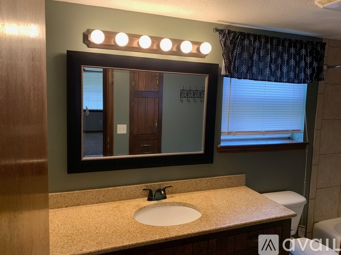 A bathroom with a sink, mirror, and toilet.