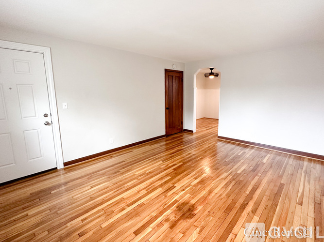 A room with wooden flooring and a white door.