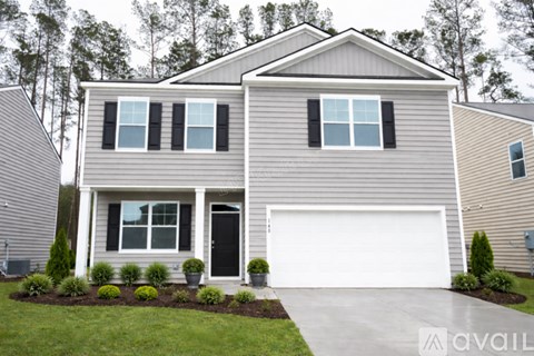 A house with a grey siding and a white garage door.