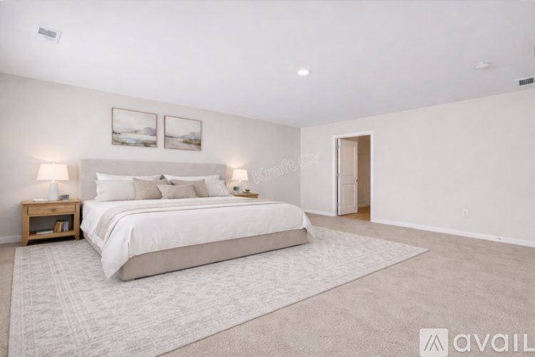 A bedroom with a large bed and two lamps on the side tables.