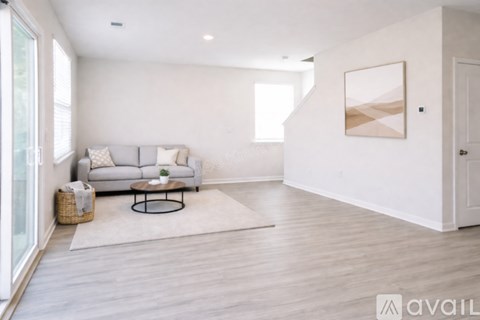 A living room with a grey couch, a coffee table, and a painting on the wall.